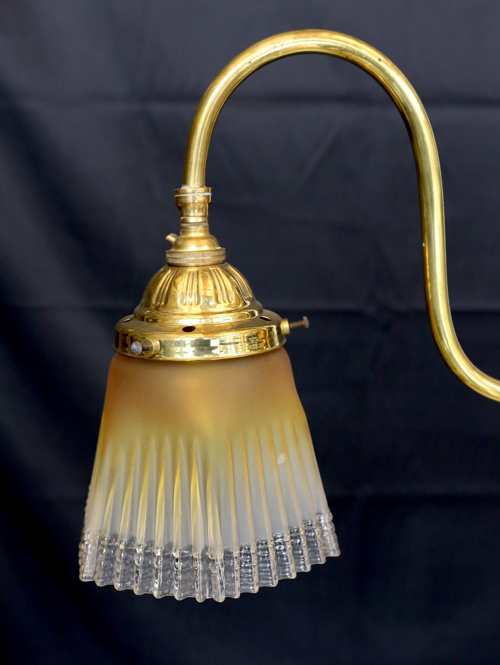 An early 20th century English brass twin branch light fitting with amber tinted tall glass shades height to top of fitting 50cm, width 77cm